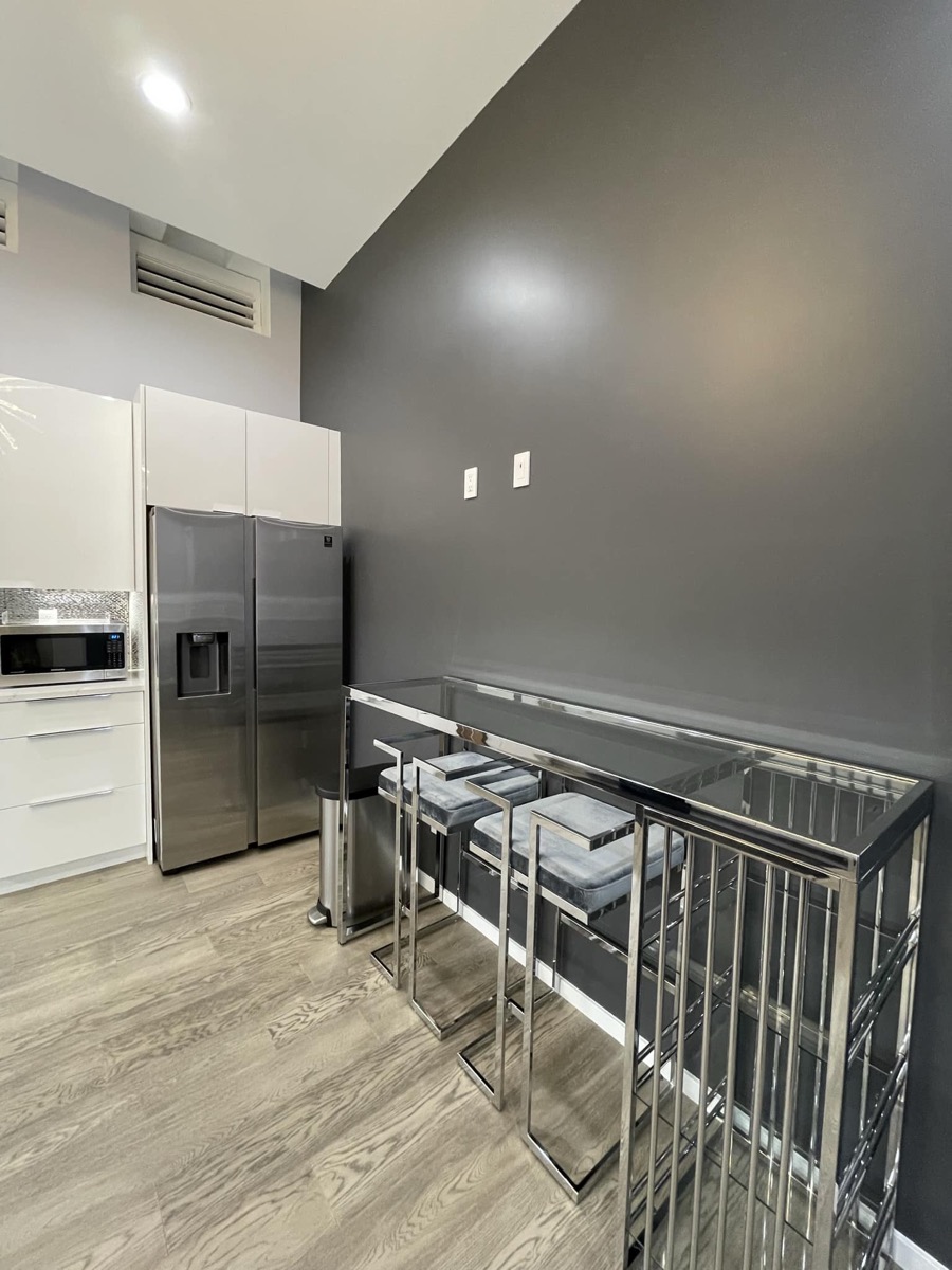 Kitchen with stainless steel refrigerator and bar seating