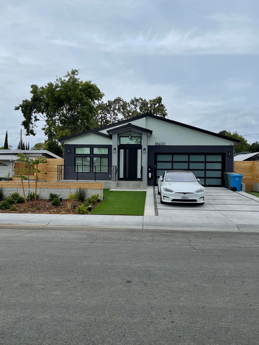 Modern home exterior with Tesla and turf lawn